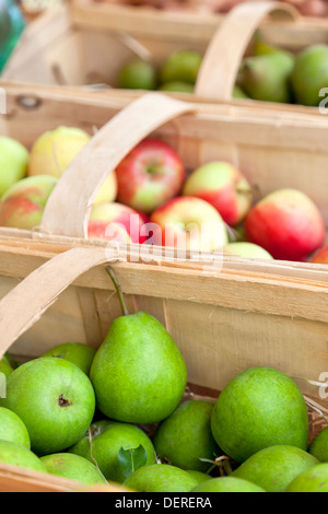 Äpfel und Birnen in Körben auf Bauernmarkt Stockfoto