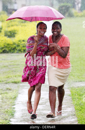 Zwei Mädchen laufen durch den Regen an ihrer High School im Luwero Distrikt von Uganda. Stockfoto