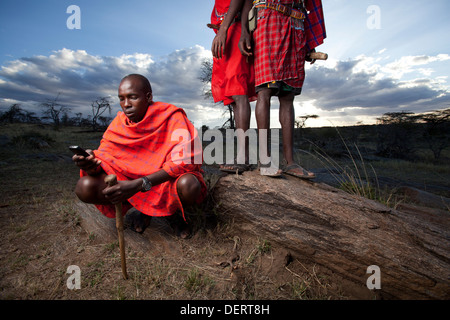 Maasai Mann senden einen Text Nachricht, Mara-Region, Kenia Stockfoto