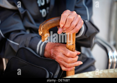 Älterer Mann Hände halten eine geschnitzte walking stick, Italien. Stockfoto