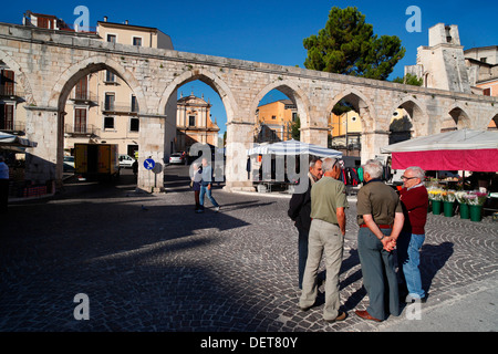 Marktstände und das mittelalterliche Aquädukt am Piazza Garibaldi in Sulmona, Italien. Stockfoto