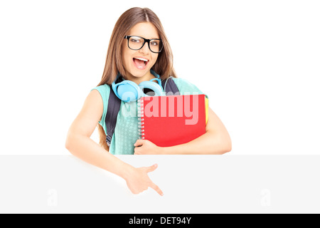 Aufgeregt Studentin hält Notizbücher und deutete auf eine Blindplatte Stockfoto