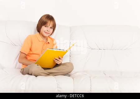 Intelligente ruhig kaukasischen junge Porträt im Innenraum auf dem Sofa sitzen und lesen Stockfoto