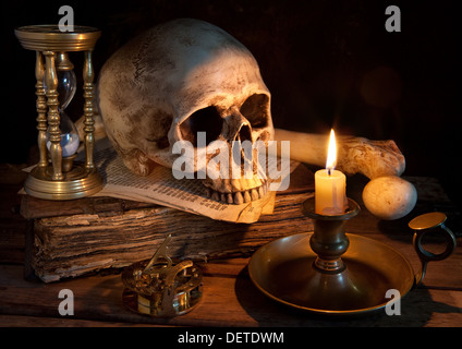 Vintage Totenkopf auf antikes Buch mit Kerze und Sanduhr Stockfoto