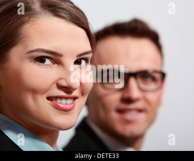 Porträt des jungen lächelnd Geschäftsfrau mit ihrem Kollegen im Hintergrund unscharf. Stockfoto