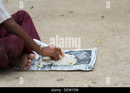 Niedrigere Kaste Indianerjunge Dosa zum Frühstück auf einer indischen Straße zu essen. Andhra Pradesh, Indien Stockfoto