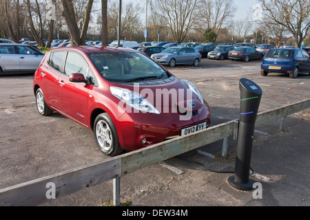 Ein Nissan Leaf Auto an eine elektrische Ladestation aufgeladen. Stockfoto