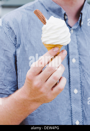 Schließen der Mann Betrieb Eis mit Konus und Flocke Stockfoto