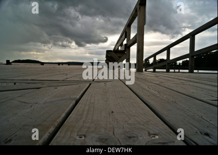 Schwere Regenwolken und Holzsteg Stockfoto