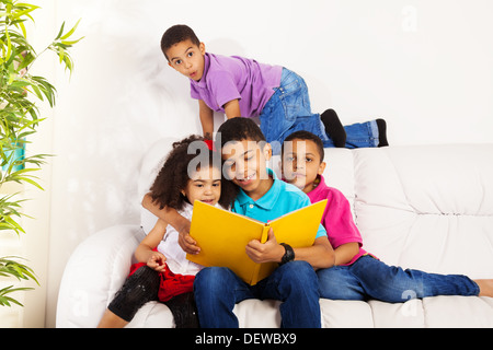 Familie, Gruppe von vier Kinder mit älteren Bruder Lesebücher, Brüder und Schwester Stockfoto