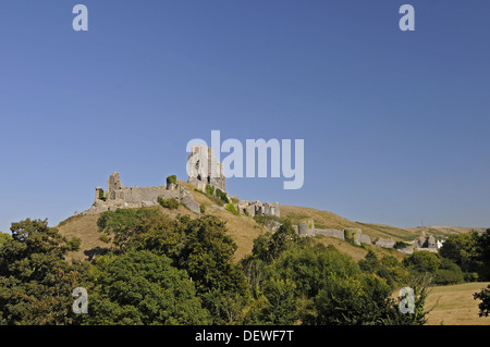 Blick über Bäume zu Ruinen von Corfe Castle mit Stadt von Corfe im Hintergrund, Isle of Purbeck-Dorset-England Stockfoto