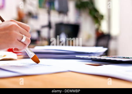 Weibliche Künstler Malerei mit Pinsel auf Papier Stockfoto