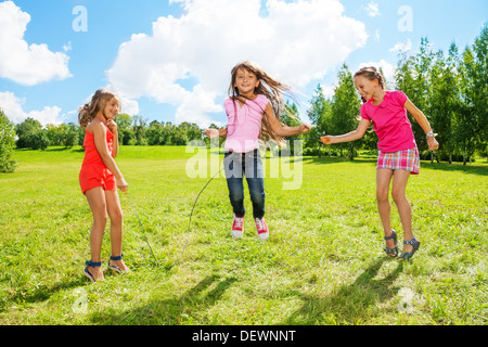 Drei Mädchen springen über das Seil im Park, Spaß in Bewegungsspiele außerhalb Stockfoto