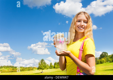 Happy Teen Blondine hält Glas mit Schmetterling, auf sonnigen Sommertag im Park stehen Stockfoto