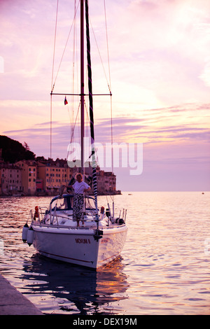 Segelboot nähert sich Rovinj bei Sonnenuntergang, Istrien, Kroatien Stockfoto