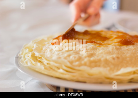 Frische Crepes mit Bio Aprikose Marmelade auf einem weißen Teller Stockfoto