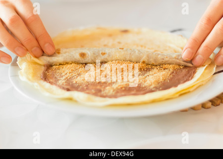 Rollende Crêpes gefüllt mit Schokoladencreme und Grind Keks Stockfoto