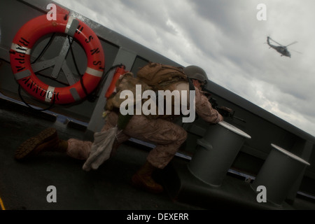 US-Marines mit Force Reconnaissance Platoon, Befehl Element, 31. Marine Expeditionary Unit(MEU) bietet Sicherheit auf dem Flugdeck der USNS Rappahannock während eines Besuch Board Search und Seizure(VBSS) Trainings, am Meer, 15. September 2013. Am 31. Dezember Stockfoto