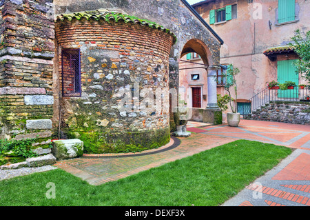 Steinmauer der mittelalterlichen Kirche bedeckt mit grünem Moos in Stadt Sirmione, Italien. Stockfoto