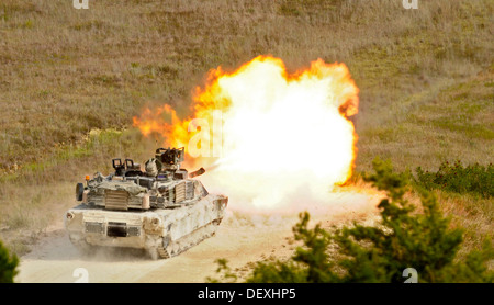 Eine US Armee M1A2 Abrams Panzer-Besatzung, das 1. Bataillon, 12. Kavallerie-Regiment, 3rd Brigade Combat Team, 1. Kavallerie-Division zugewiesen feuert eine 120 mm Runde aus seiner Kanone auf ein Ziel für die Besatzung Qualifikation während einer Gunnery Tabelle VI Leben Feuer Übung eine Stockfoto