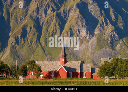 Die rote Daube Kirche Flakstad vor steilen Bergen, Vareid, Fredvang, Insel Flakstadøya, Flakstadoya Stockfoto