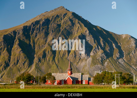 Die rote Daube Kirche Flakstad vor steilen Bergen, Vareid, Fredvang, Insel Flakstadøya, Flakstadoya Stockfoto