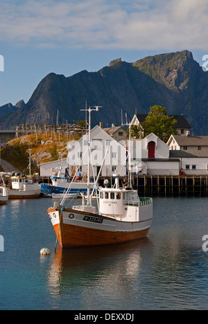 Ein Boot in der norwegischen See, Berge im Rücken, Hamnøy, Insel Moskenesøy, Moskenesoy, Lofoten Inselgruppe, Nordland Stockfoto