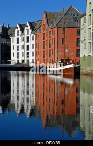 Häuser und ein Segelboot spiegelt sich in dem ruhigen Wasser der innere Hafen von Ålesund, Alesund, Moere Og Romsdal, Norwegen, Europa Stockfoto