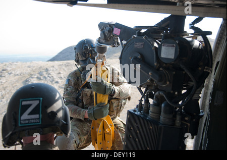 US-Armee Sgt. Brandon Coburn, Sanitäter mit der Medevac-Zug "Dustoff," Charlie Kompanie, 3. Bataillon, 238. Aviation Regiment, Task Force Dragon, Abseilen von einem UH-60 Black Hawk Hubschrauber auf einer Hebebühne steht während einer Übung in der Nähe von Forward Operating Stockfoto