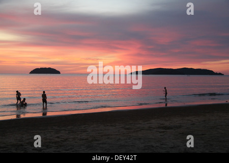 Sonnenuntergang am Strand Menschen im Meer Stockfoto