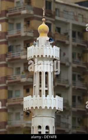 Das Minarett einer kleinen Moschee vor einem Mehrfamilienhaus mit Balkonen, Abu Dhabi, Vereinigte Arabische Emirate Stockfoto