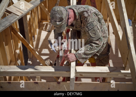 PAKTYA Provinz, Afghanistan – US Army Spc. Stephen Burris, ein Soldat mit dem 149. vertikale Baukonzern, Kentucky Nationalgarde, benutzt einen Hammer ein Fachwerkbinders im Nagel, legen Sie bei der Erstellung eines Gebäudes, das als Wohnräume für verwendet wird Stockfoto