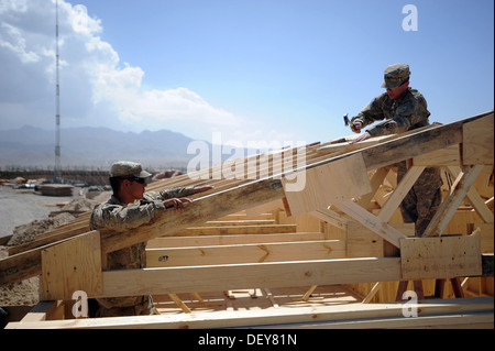 PAKTYA Provinz, Afghanistan – US Army Spc. Jared Jordan (links), unterstützt wie Sgt. Dale Fletcher, beide Soldaten mit dem 149. vertikale Baukonzern, Kentucky Nationalgarde, einen Hammer um ein Fachwerk im Nagel, um bei der Konstruktion zu platzieren verwendet eine Stockfoto