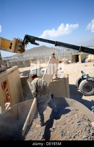 US-Armee Soldaten mit dem 149. vertikale Baukonzern, Kentucky Nationalgarde, heben ein Fachwerkbinders, damit sie es einziehen können, beim Bau eines Gebäudes zu platzieren, die für die Soldaten auf Forward Operating Base Maul als Wohnbereich verwendet werden Stockfoto