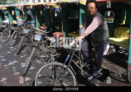 Chinesischer Mann sitzt rittlings auf einem Zyklus fahrradrikscha Fahrradrikscha in der Stadt Ping Yao offiziell Pingyao antike Stadt in der Provinz Shanxi, China Stockfoto