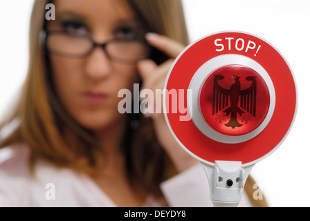 Frau mit einer roten Polizei Signalisierung Scheibe mit dem Bundesadler Stockfoto