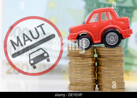Miniatur-Auto auf einen Stapel von Münzen, Maut symbolisches Bild für Auto Stockfoto