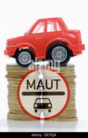 Miniatur-Auto auf einen Stapel von Münzen, Maut symbolisches Bild für Auto Stockfoto