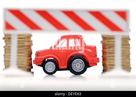 Miniatur-Auto zwischen Stapeln von Münzen, symbolisches Bild für Auto-Maut und Steuern Stockfoto