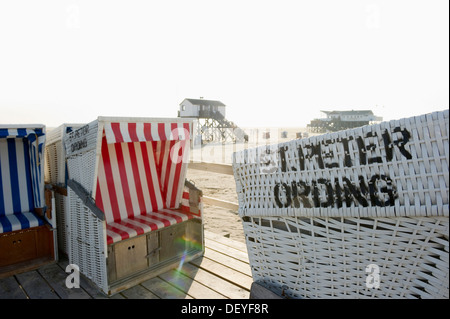 Überdachten Strand Strandkörben am Strand vor den Häusern auf Stelzen, St. Peter-Ording, Schleswig-Holstein, Deutschland Stockfoto