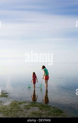 Frau und Mädchen mit Dip Netze stehen im Wattenmeer, Wyk auf Föhr, Föhr, Schleswig-Holstein, Deutschland Stockfoto