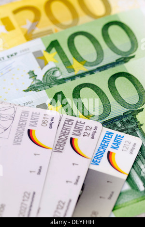 Krankenversicherungskarten auf Banknoten, zusätzliche Beiträge für die Krankenversicherung Stockfoto