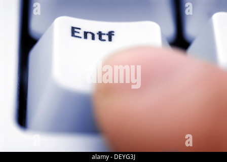 Finger, drücken Sie die Entf-Taste auf einer Computertastatur, symbolisches Bild für die Löschung der gespeicherten Daten Stockfoto