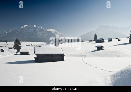 Verschneite Almen und Heustadel, Wettersteingebirge hinten, Mittenwald, Upper Bavaria, Bavaria, Germany Stockfoto