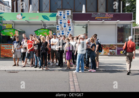 Junge Touristen am Checkpoint Charlie, Friedrichstrasse - Berlin-Deutschland mit Kopfsteinpflaster zeigt den Verlauf der Mauer Stockfoto