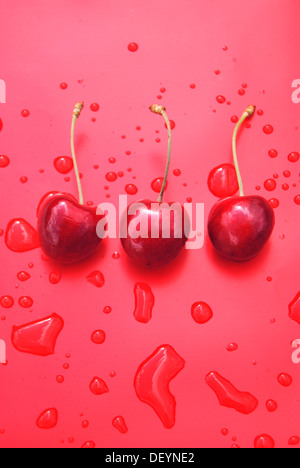 Drei rote reife Kirschen mit Wassertropfen Stockfoto