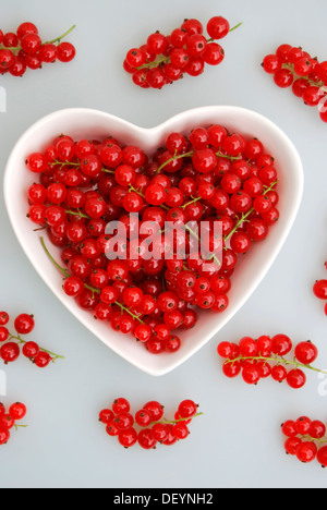 Rote Johannisbeere (Ribes Rubrum) in einer herzförmigen Porzellanschüssel Stockfoto