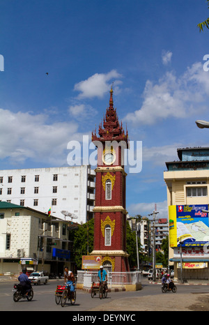 Menschen fahren Sie vorbei an der Uhrturm in zentralen Mandalay. Stockfoto