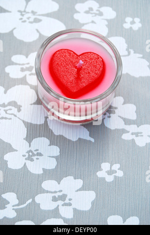 Herzförmige Kerze in einem Glas Teelicht Halter, Symbol für die Liebe Stockfoto