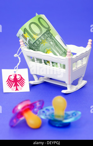 Kind Wiege mit Euro hundert und Label mit Bundesadler, symbolische Foto Pflege Geld, Kinderwiege Mit Hundert-Euro-Schein Und Stockfoto